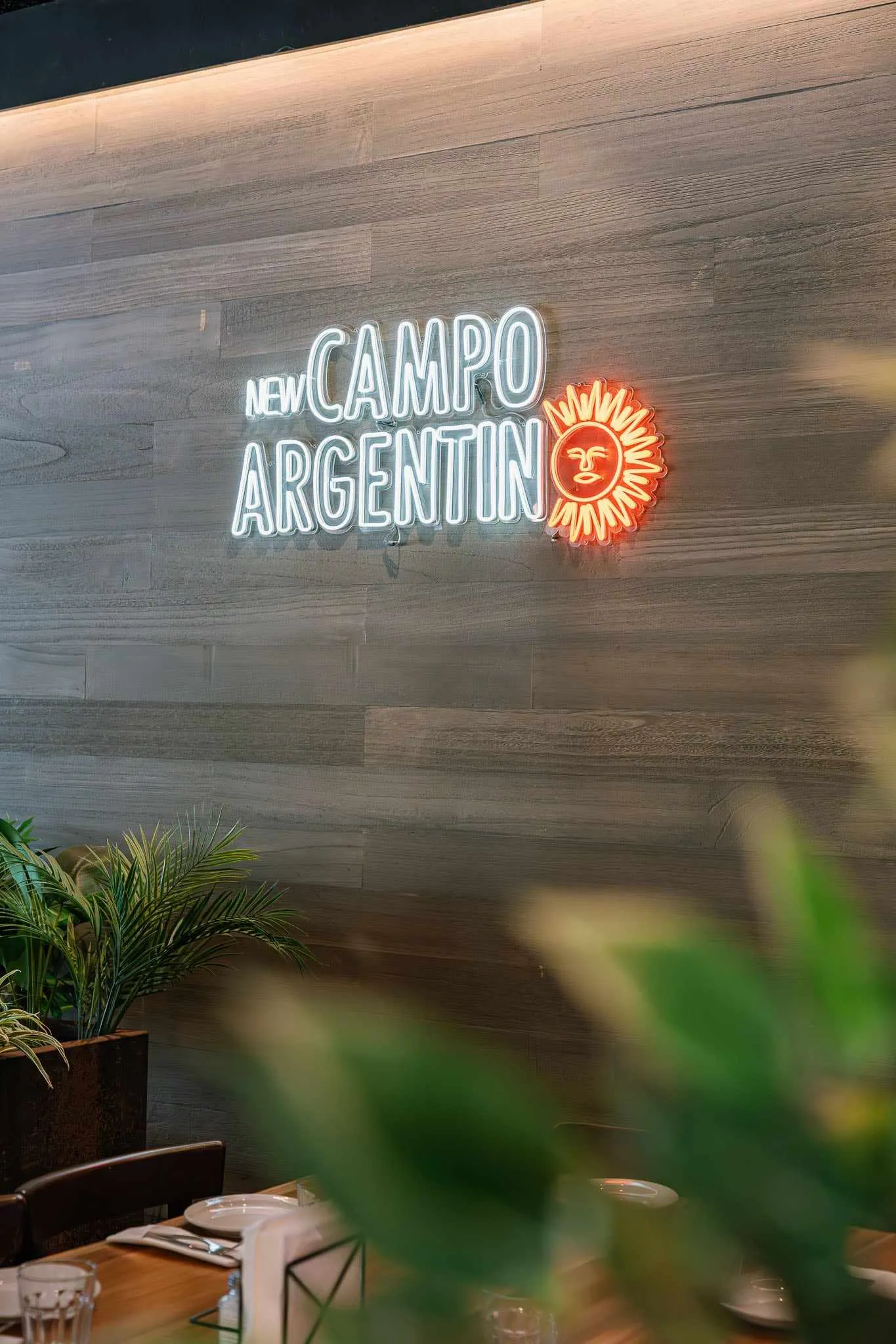 The New Campo Argentino neon sign glowing over the dining room