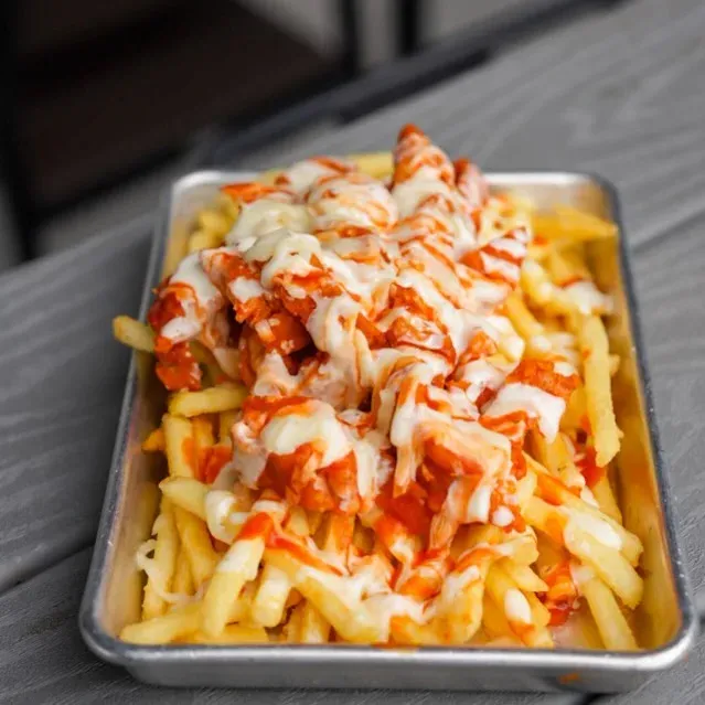 Hot and Loaded fries topped with buffalo chicken tenders, queso, mozzarella, and sauce