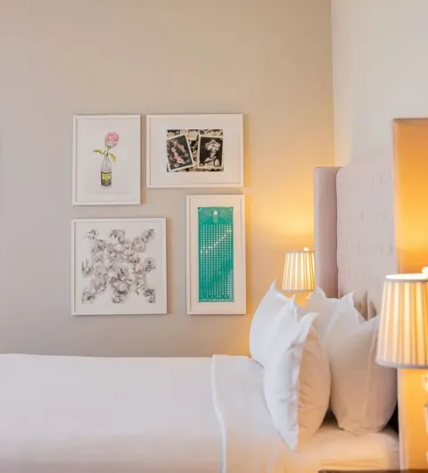 Bedside table lamps and curated art pieces above the bed in Classic Terrace Double at The Plymouth Hotel South Beach