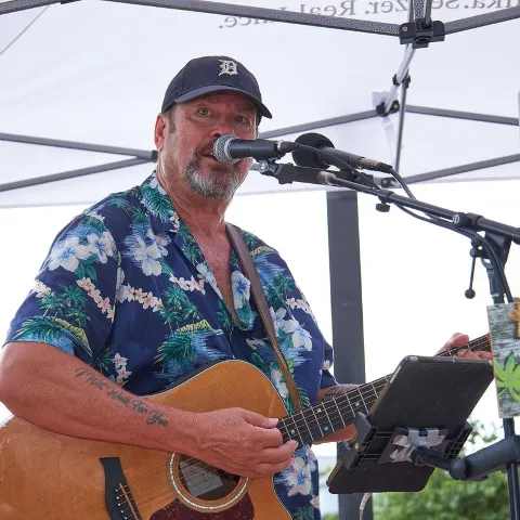 An artist playing live music outside.