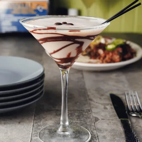 Espresso Martini served on a table with food.