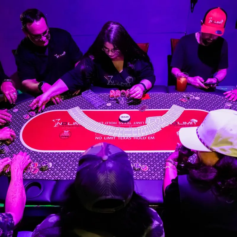 Group of people playing a casino card game around a table.