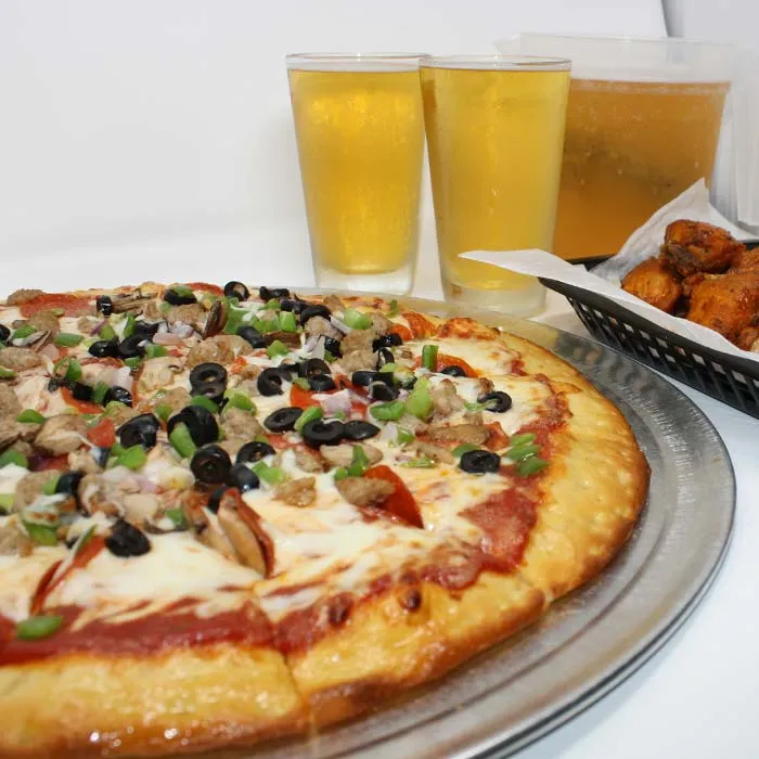 FUBAR Pizza Bar restaurant pizzeria in Fort Walton Beach, Florida waterfront supreme pizza, basket of chicken wings and ice cold tap beer