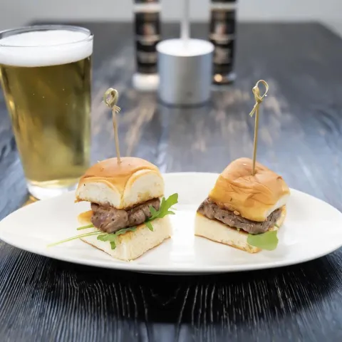 Tenderloin sliders served with a glass of beer.