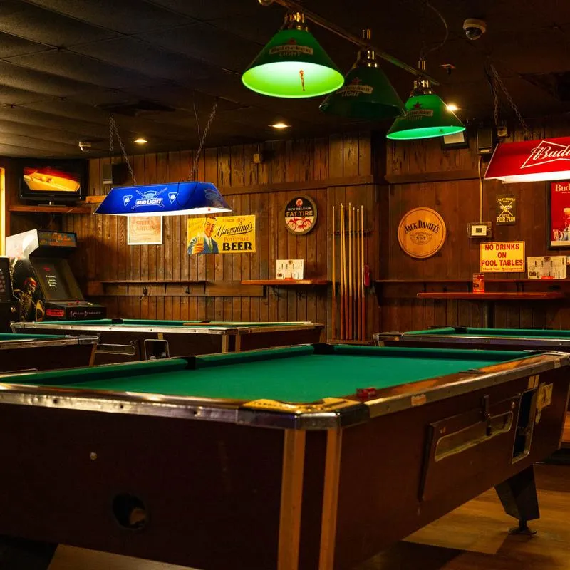 Pool hall with tables and beers signs.