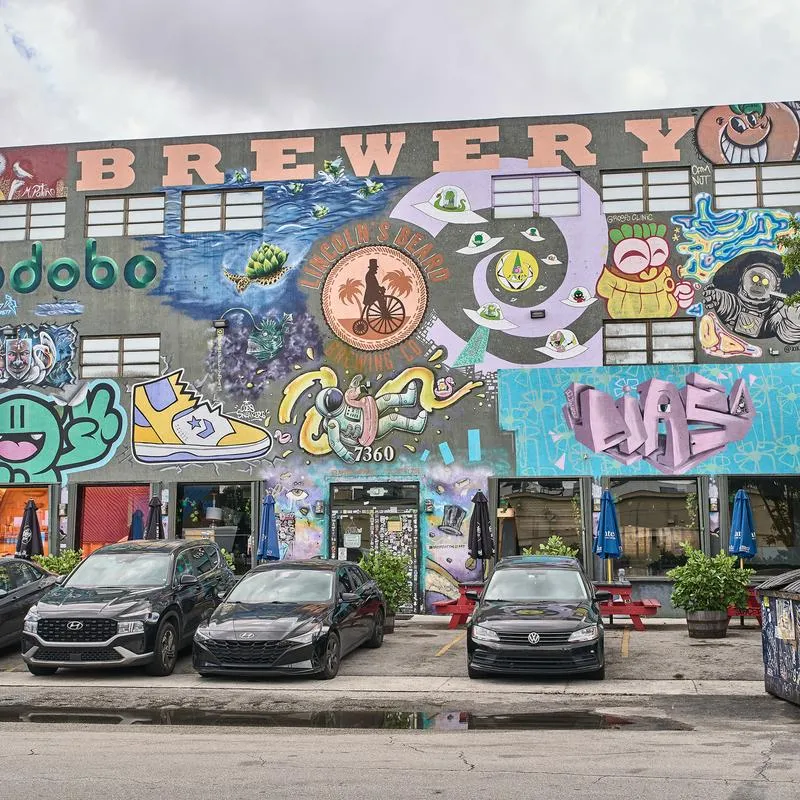 View of the brewery building with extensive graffiti art covering its exterior walls.