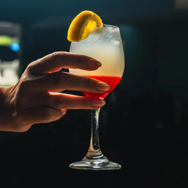 Hand holding a cocktail.