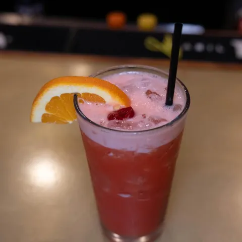 Painkiller cocktail garnished with a slice of orange.