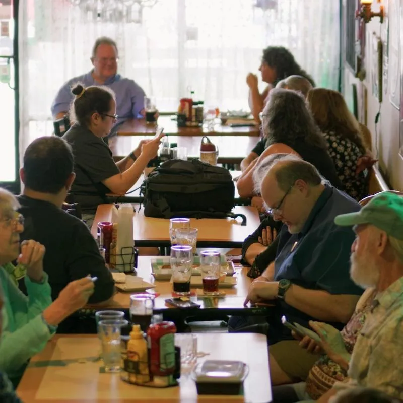 People sitting at the tables inside of pub.