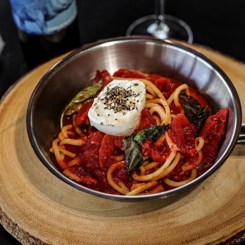 Bucatini pasta, with tomato sauce, basil and sour cream.