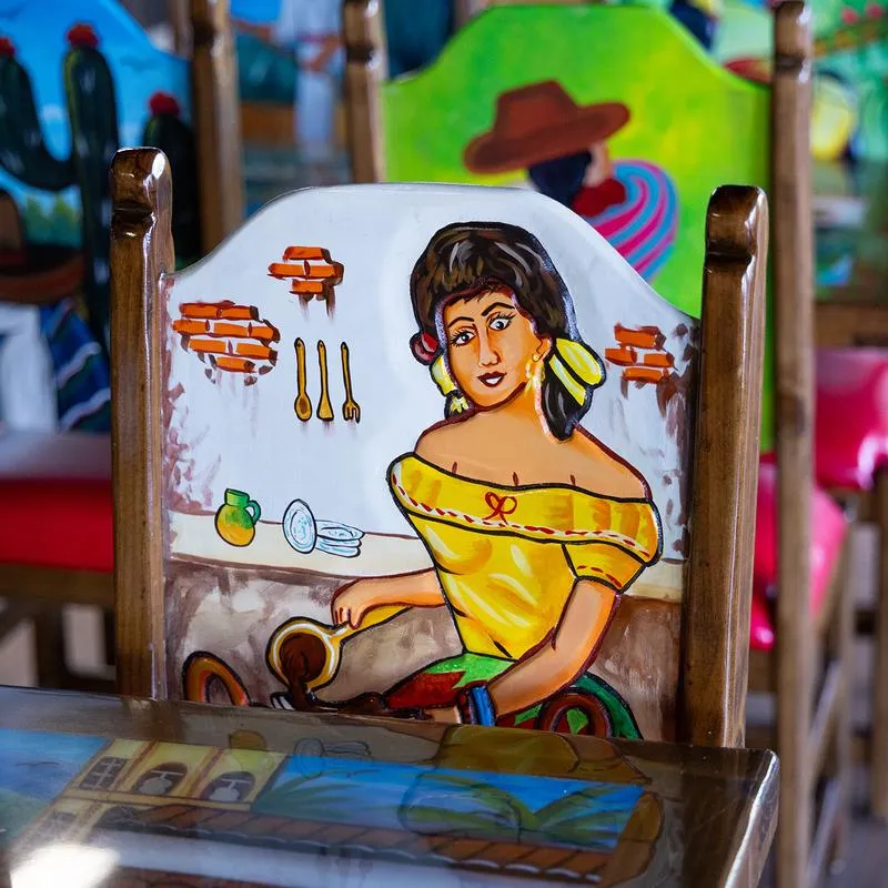 Dining area, hand painted wooden chairs with motifs depicting traditional life.