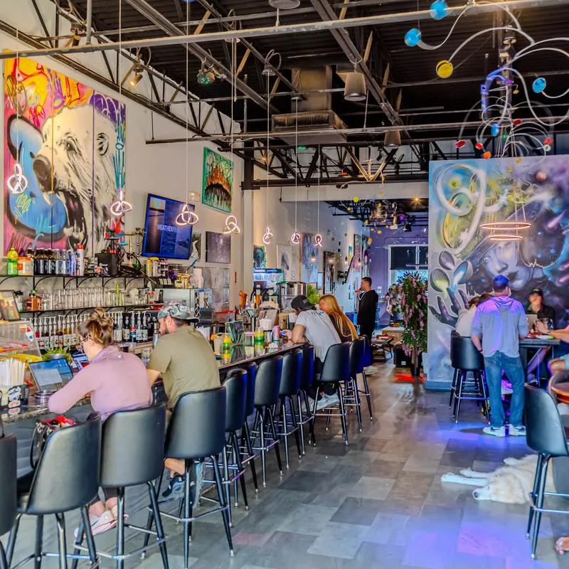 Interior featuring colorful mural artwork on the walls and bar stools along a counter.