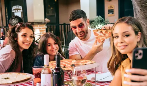 Patrons taking a selfie with pizza