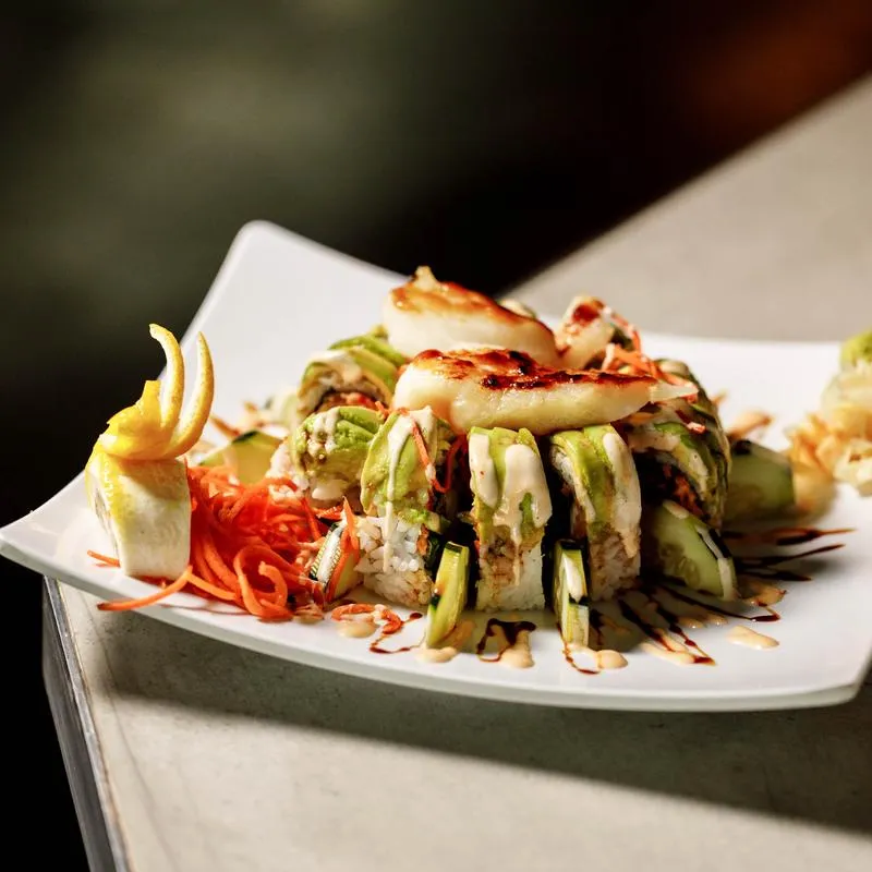 Lobster tempura sushi rolls, topped with avocado and grilled shrimp.